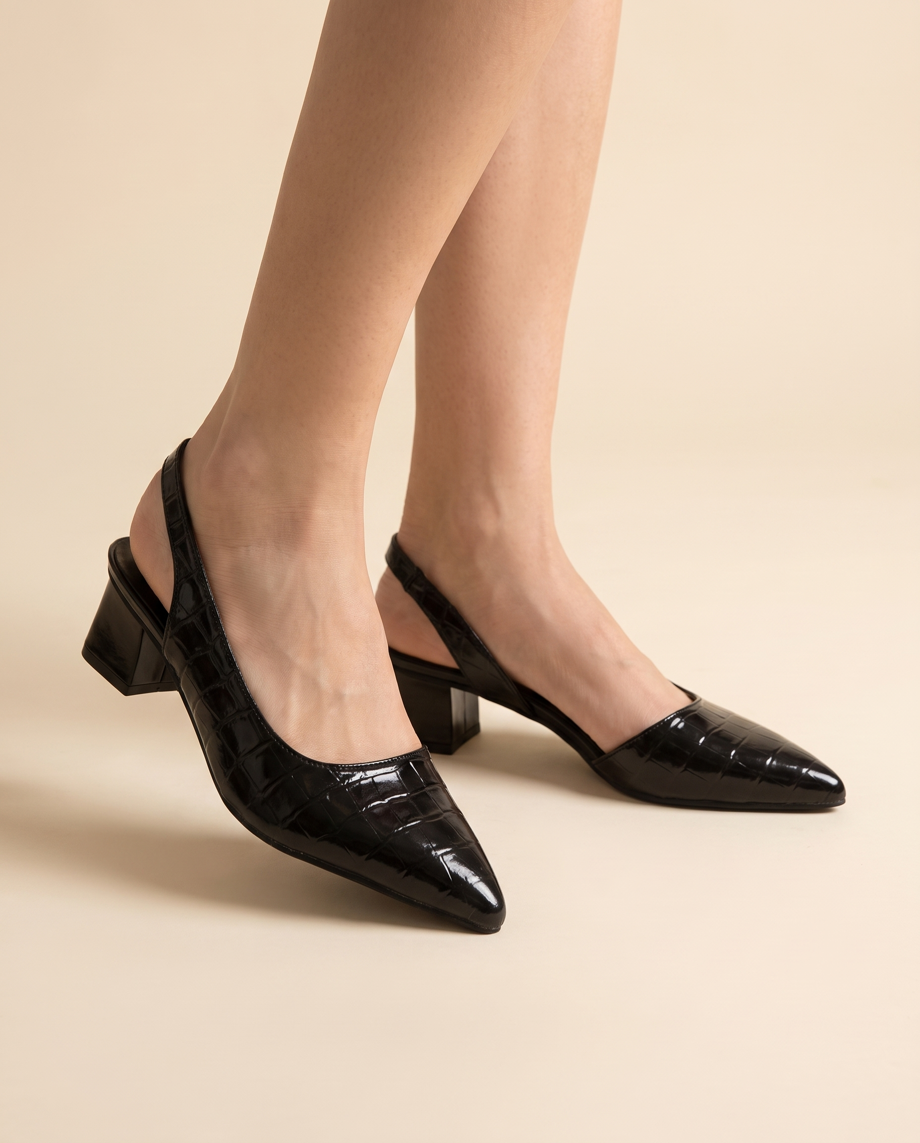 Woman wearing Solène black slingback block heels, studio shot