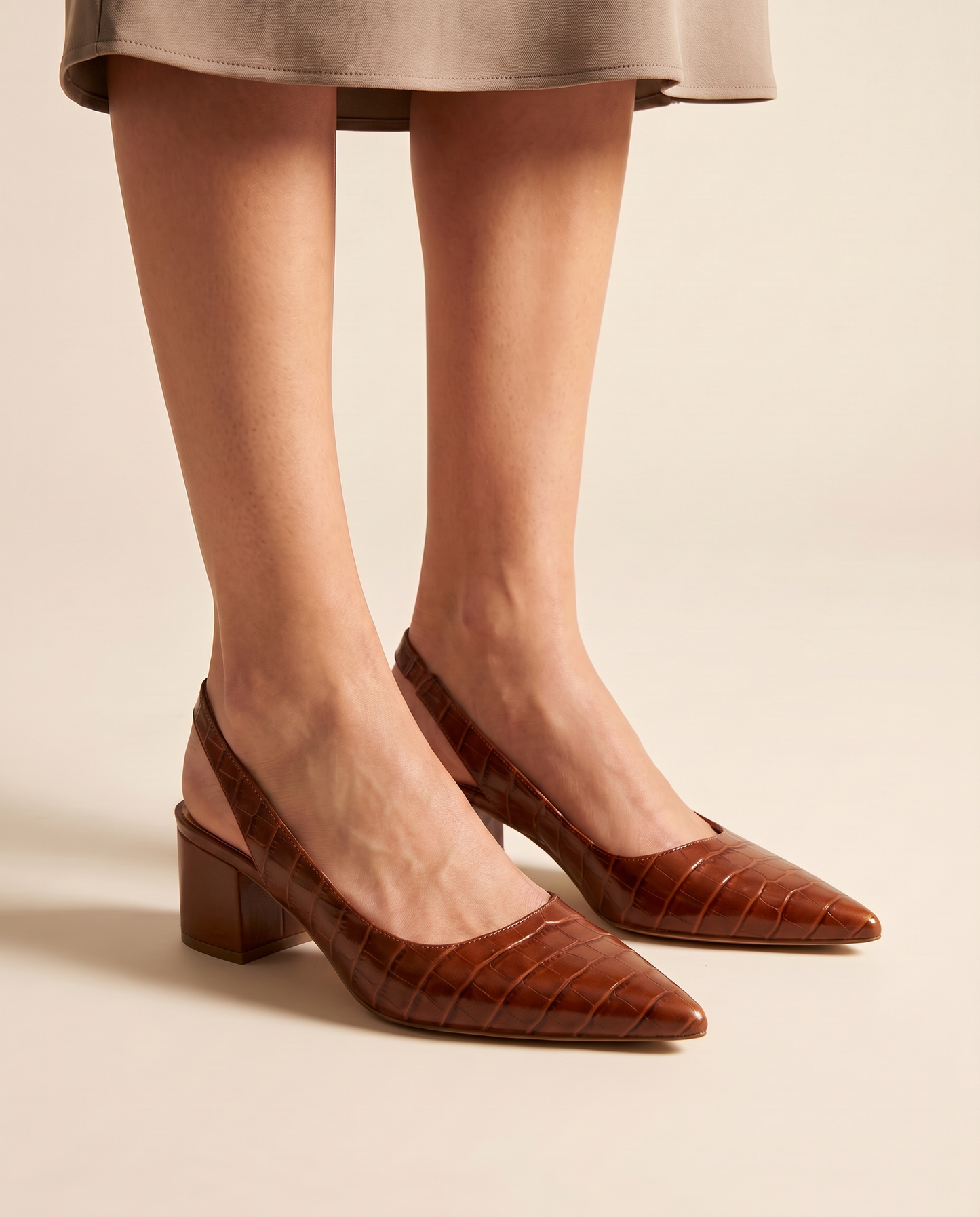 Woman wearing Solène brown croc slingback block heels, studio shot